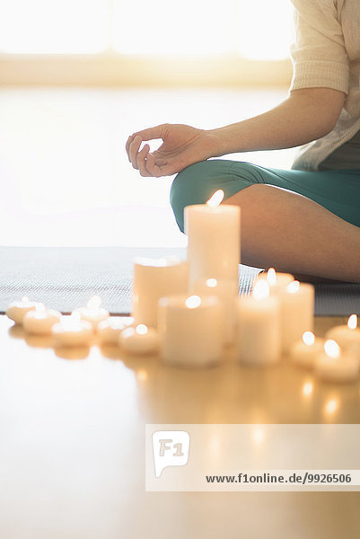 Woman meditating surrounded by candles