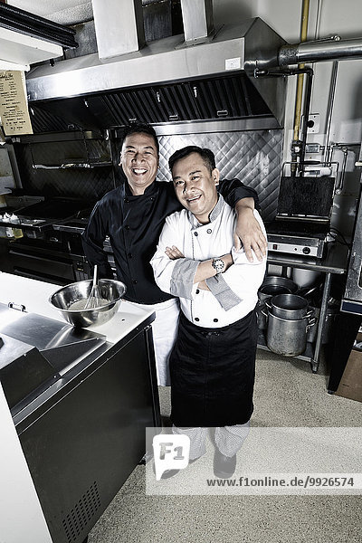 Two cooks in a commercial restaurant kitchen.