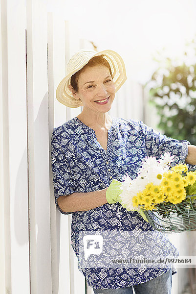 Portrait of smiling senior woman with flowers