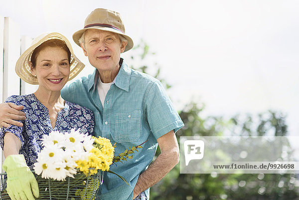Portrait of smiling senior couple with flowers