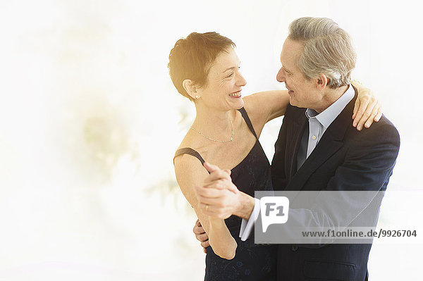 Elegant senior couple dancing while celebrating their anniversary
