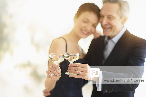 Elegant senior couple celebrating their anniversary with champagne toast