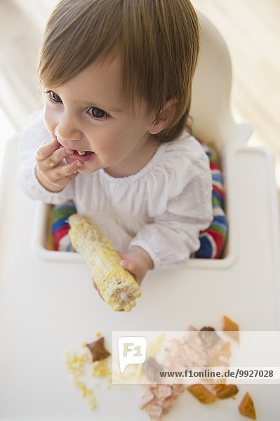 Girl (2-3) eating sweet corn