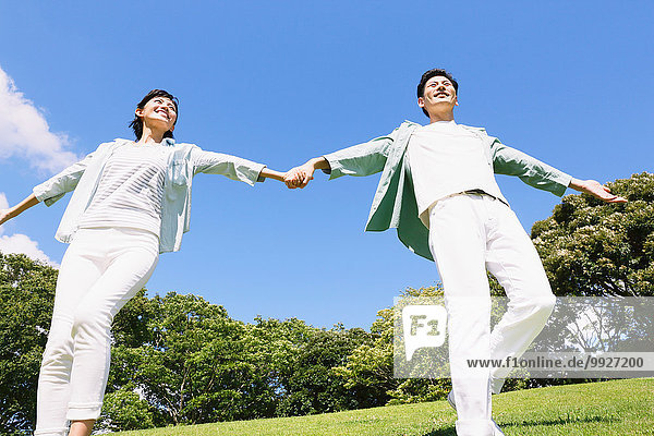 Happy Japanese couple in a park