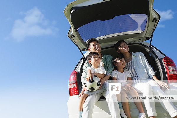 Happy Japanese family with car and blue sky