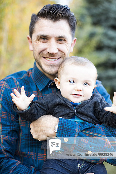 Portrait of smiling man with little son (6-11 months)