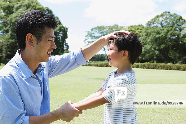 Happy Japanese father and son in a city park
