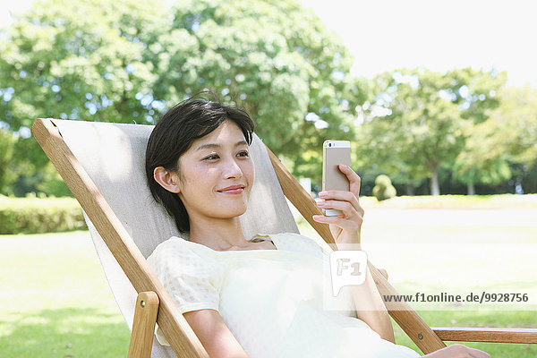 Frau Stuhl Großstadt Terrasse japanisch Smartphone