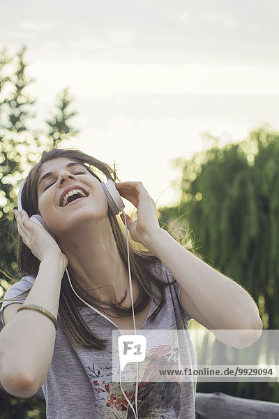 Young woman listening to music through headphones