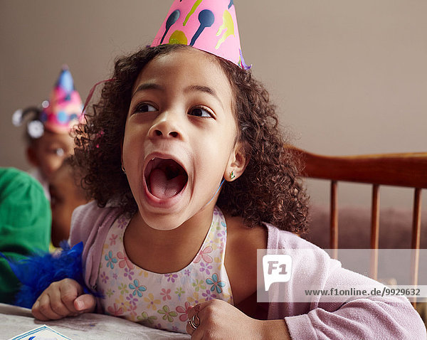 Shouting girl wearing party hat with mouth open