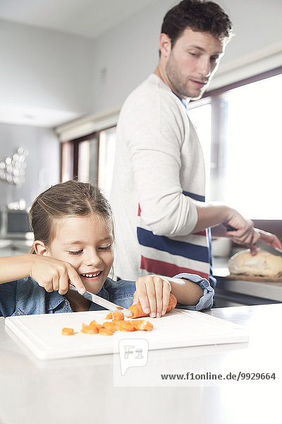Kleines Mädchen hilft ihrem Vater bei der Zubereitung des Essens in der Küche.