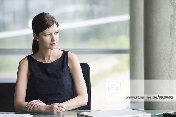 Business executive at desk looking away contemplatively