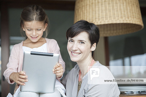 Mutter und Tochter verwenden gemeinsam ein digitales Tablett