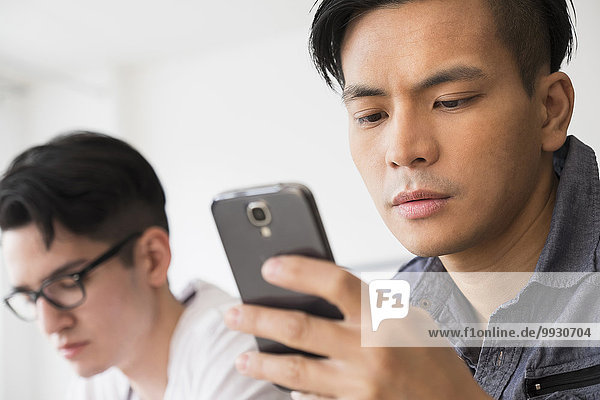 Close up of serious man texting on cell phone