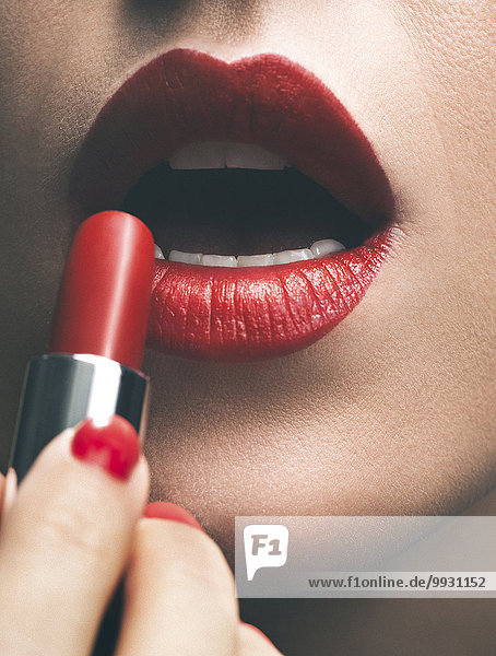 eincremen verteilen Frau Lippenstift Close-up rot auftragen