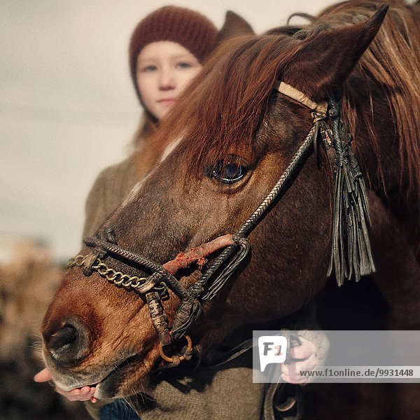 Caucasian girl holding rein of horse