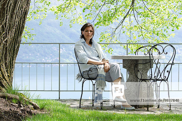 Woman sitting in a patio with sea view in Ticino  Switzerland.