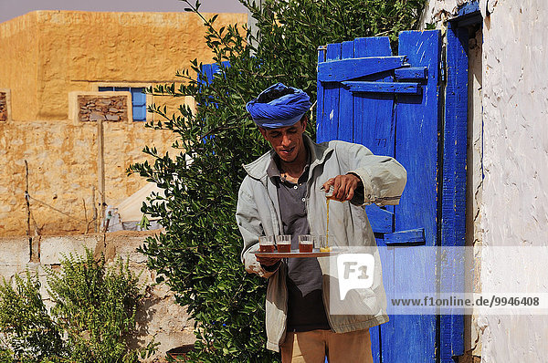 Mann beim Einschenken von Tee  Chinguetti  Region Adrar  Mauretanien  Afrika