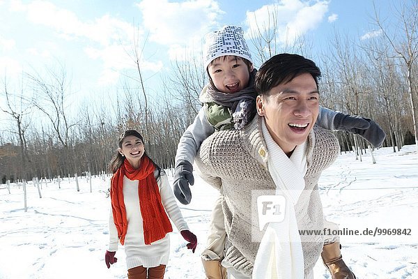 Father with his son and mother running in the snow