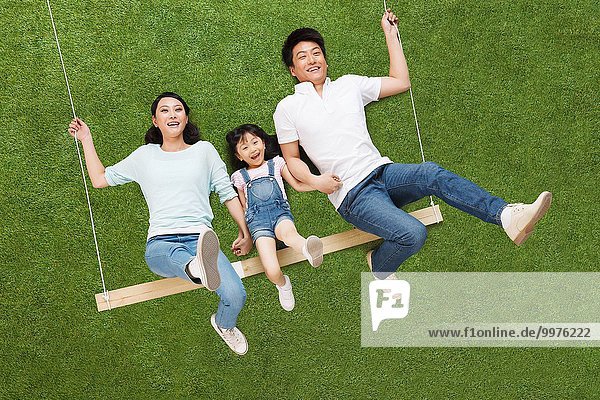 The happiness of a family of three lying on the grass