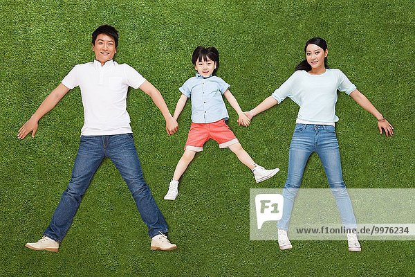 The happiness of a family of three in lying on the grassland