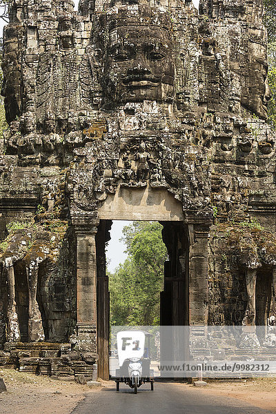 Siegestor im Osten von Angkor Thom  Tuk-Tuk vor einem Avalokiteshvara Gesichtsturm  Westansicht  Angkor Thom  Siem Reap  Kambodscha  Asien