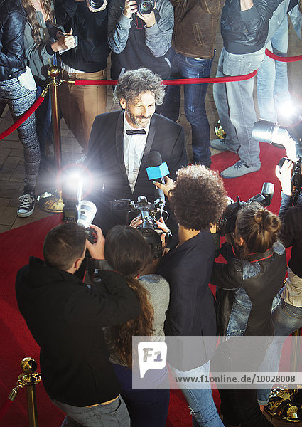 Berühmtheit wird von Paparazzi auf der Veranstaltung interviewt und fotografiert.
