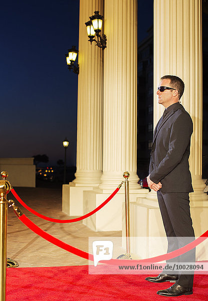 Seriöser Bodyguard mit Sonnenbrille zum Schutz des roten Teppichs bei der Veranstaltung