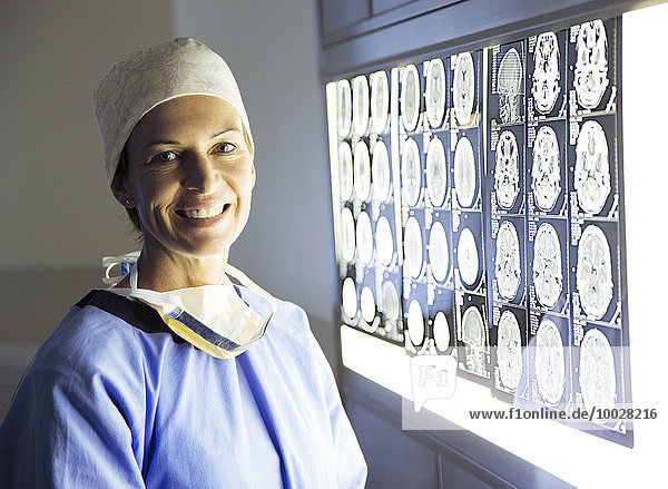 Porträt eines lächelnden Chirurgen bei der Untersuchung von MRT-Scans
