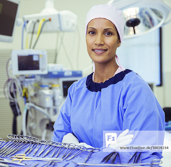 Porträt eines selbstbewussten Chirurgen in der Nähe einer chirurgischen Schere im Operationssaal