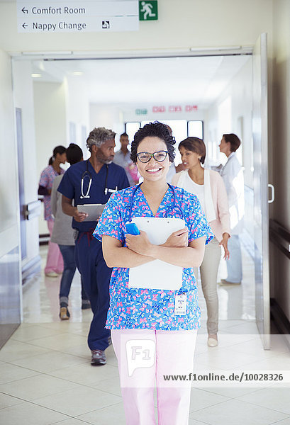 Porträt der selbstbewussten Krankenschwester mit Zwischenablage im Krankenhausflur