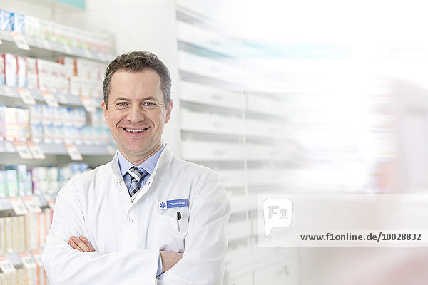 Portrait of smiling pharmacist with arms crossed in pharmacy