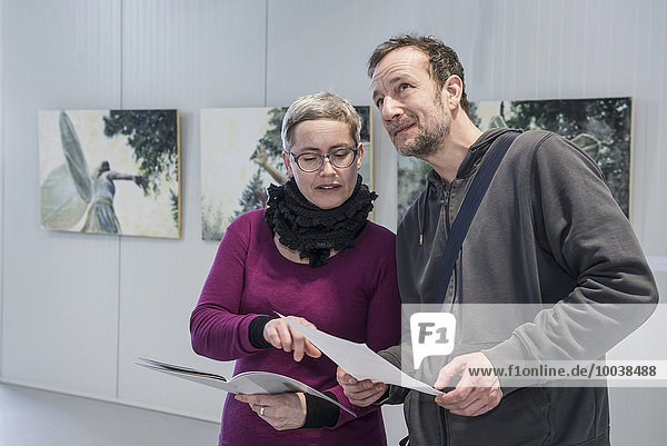Visitors discussing about painting in an art gallery  Bavaria  Germany