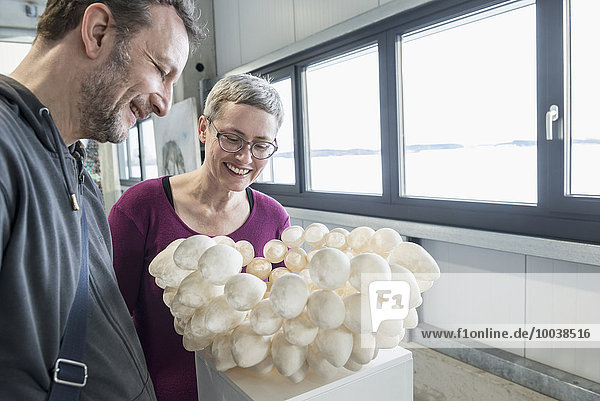 Couple looking at egg shell lampshade in an art museum  Bavaria  Germany
