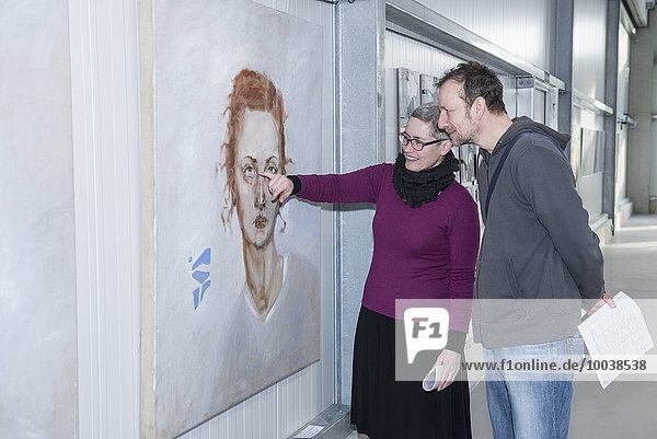 Visitors looking at paintings in an art gallery  Bavaria  Germany