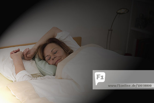 Senior woman sleeping on bed in bedroom  Munich  Bavaria  Germany