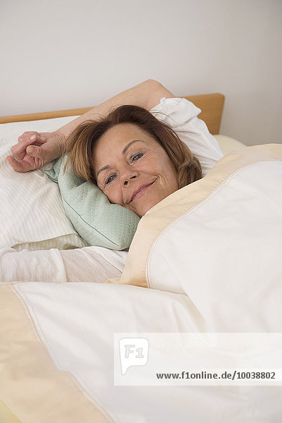 Senior woman sleeping on bed in her bedroom at home  Munich  Bavaria  Germany
