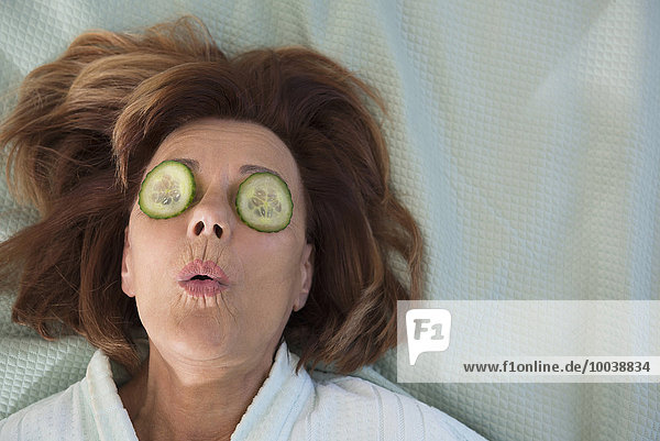 Senior woman with cucumber slices on her eyes  Munich  Bavaria  Germany