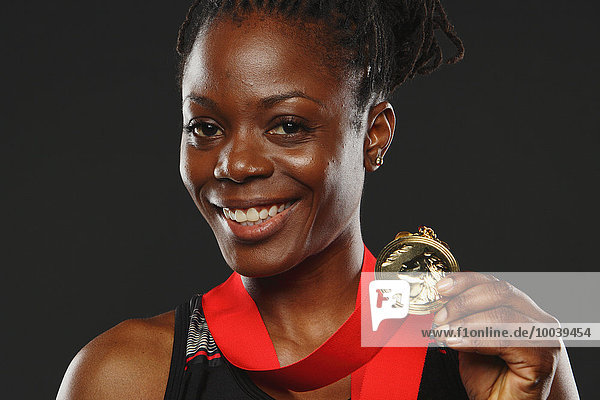 African Woman Showing Medal and Smiling