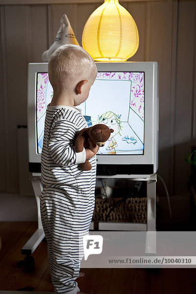 Baby boy standing in front of TV