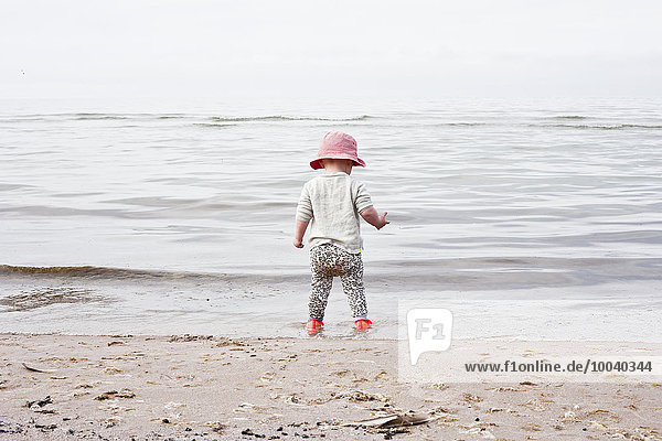 Baby girl standing on beach