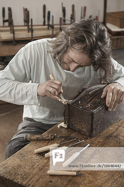 Carpenter restoring an antique bone box at workshop  Bavaria  Germany