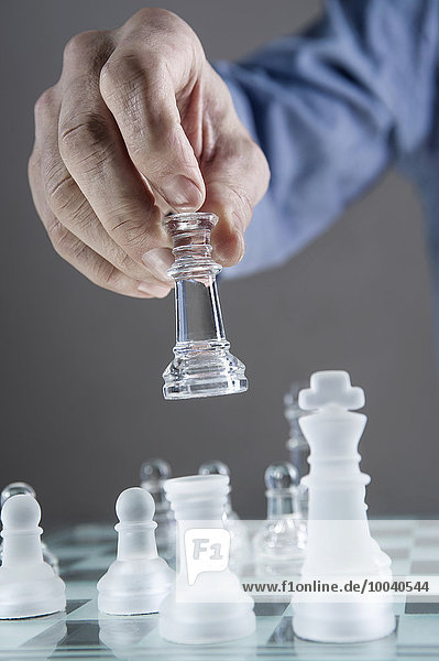 Close-up of man's hand going for checkmate while playing chess  Bavaria  Germany