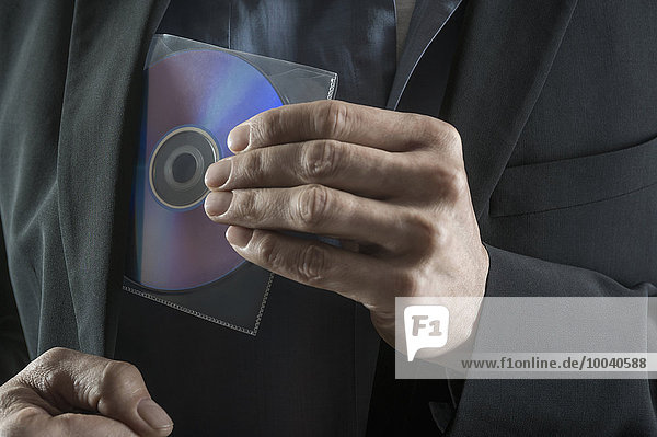 Businessman stealing compact disk  Bavaria  Germany