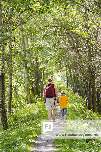 Mother with son walking through forest