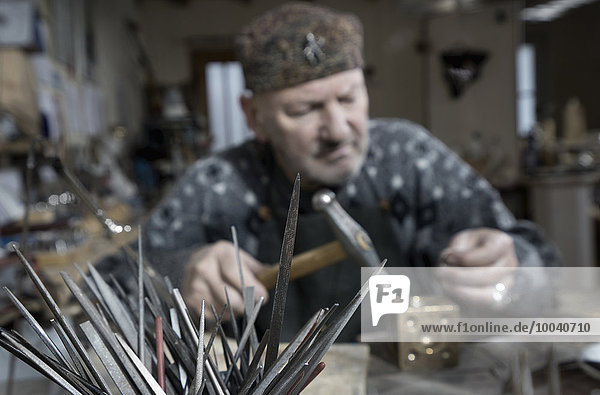 Senior male goldsmith metalworking at workshop  Bavaria  Germany