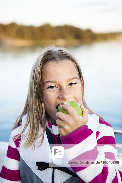 Smiling girl eating apple