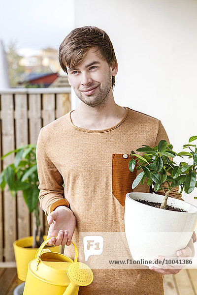 Young man with plant in pot