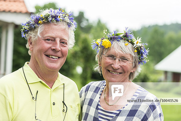 Portrait of senior couple wearing flower wreath