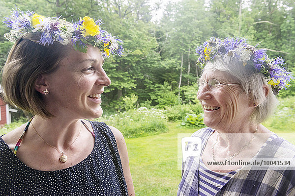 Smiling women wearing flower wreath